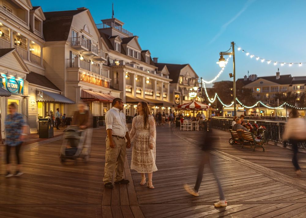 Gillian & Miles' anniversary photos at Disney Boardwalk. Gillian in white lace Ivy City Co dress, dusk boardwalk. Cred: LexTakePix