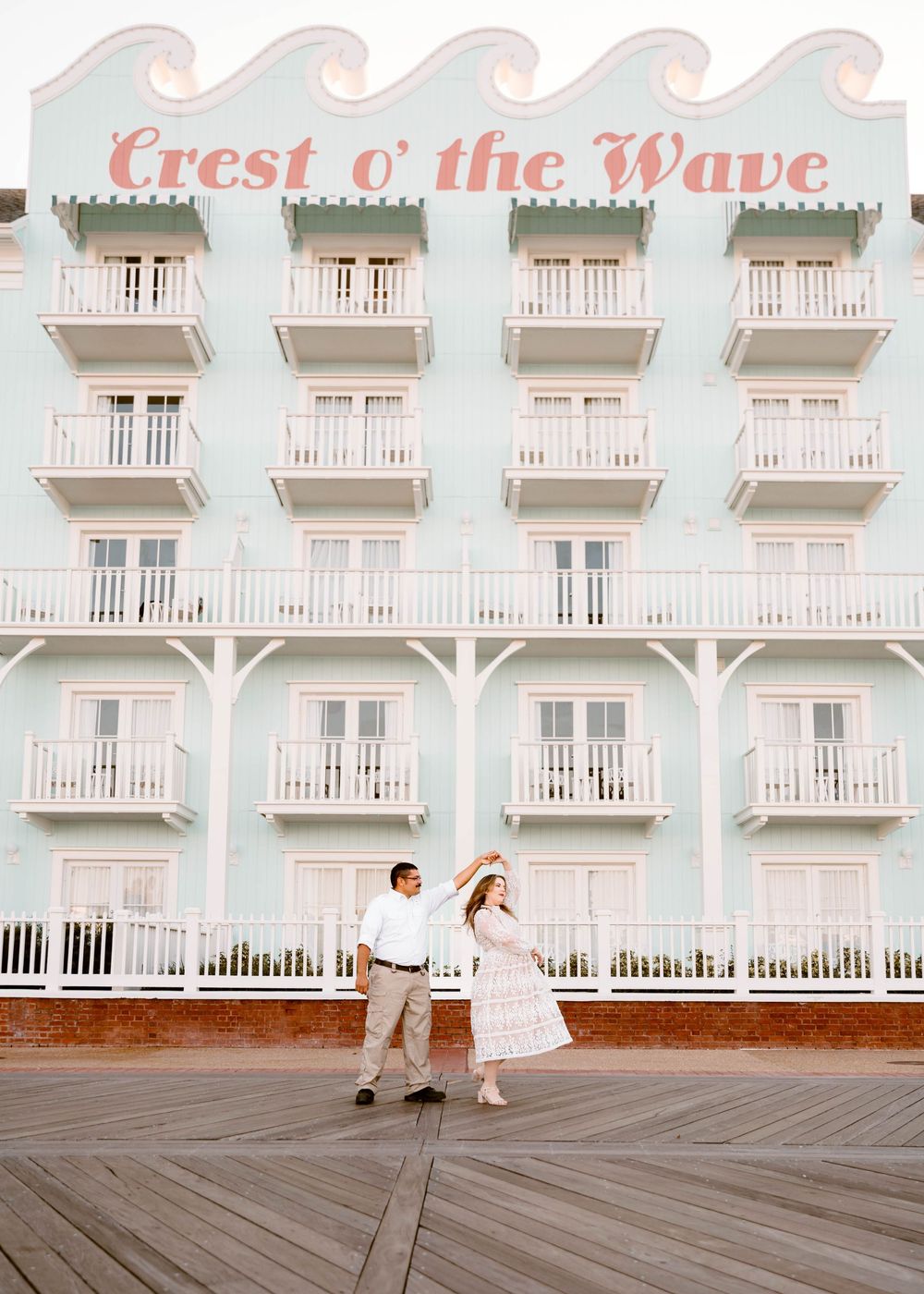 Gillian & Miles' anniversary photos at Disney Boardwalk. Gillian in white lace Ivy City Co dress, dancing on boardwalk Cred: LexTakePix