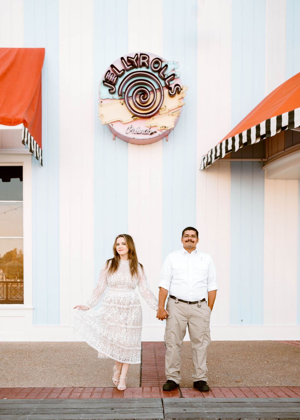 Gillian & Miles' anniversary photos at Disney Boardwalk. Gillian in white lace Ivy City Co dress, outside of Jelly Rolls. Cred: LexTakePix