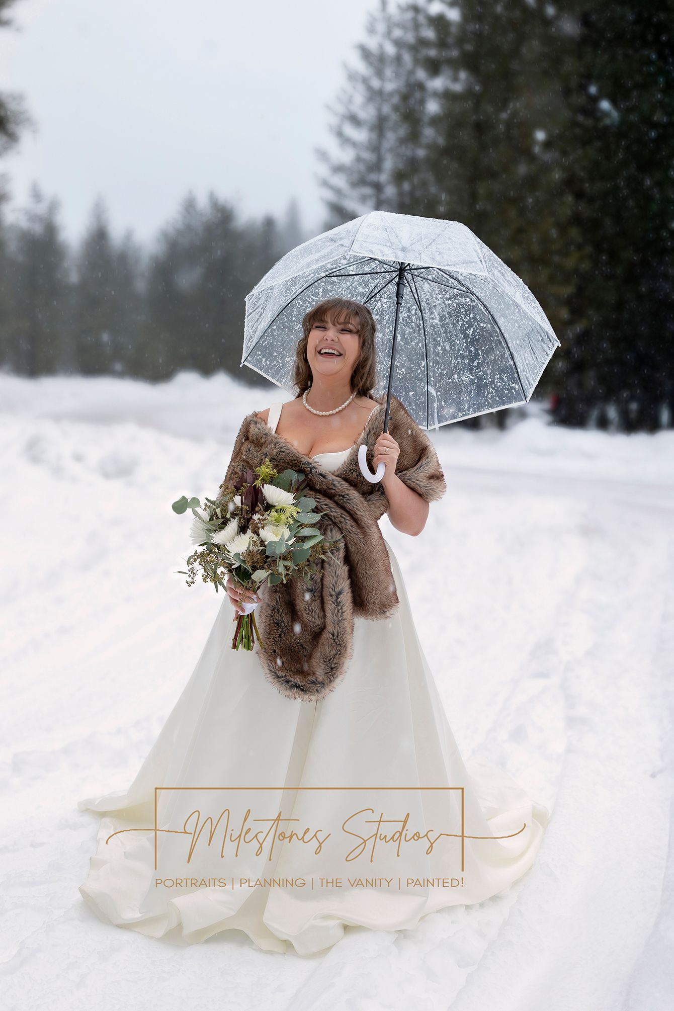 bride holding clear umbrella laughing in the snow