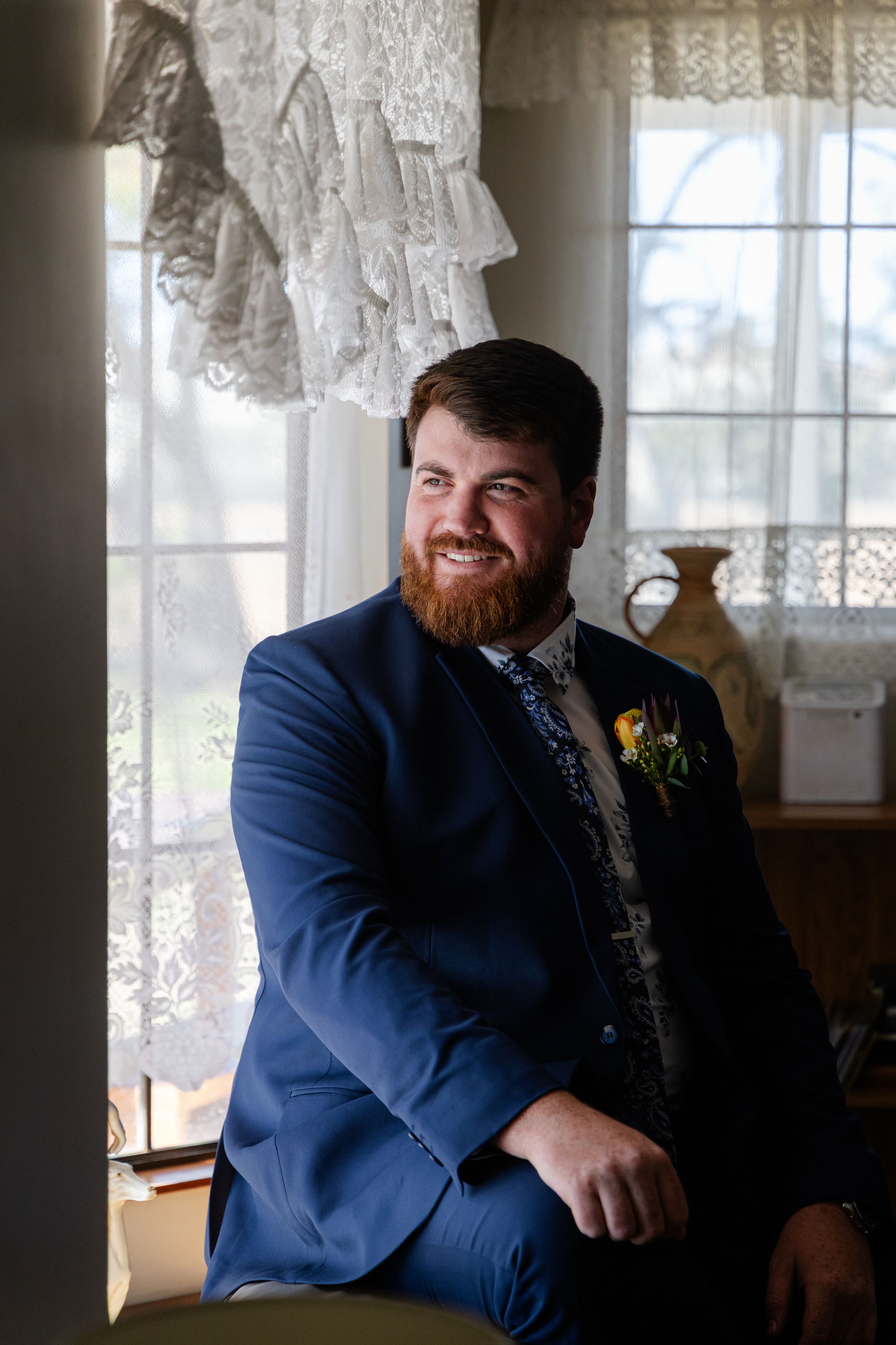 Groom sitting by the window. Homestead Wedding Australia