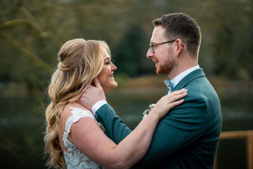 Ein Brautpaar umarmt sich fotoshooting – die Braut in Weiß, der Bräutigam in Teal – und teilt einen glücklichen Moment.