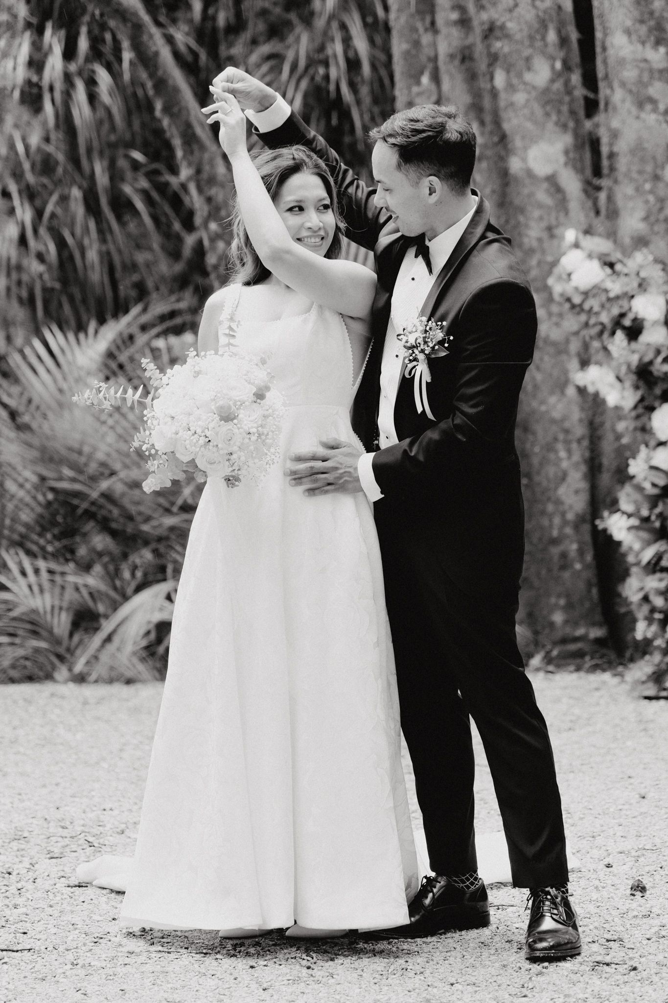 A romantic black and white wedding photo shows a couple dancing captured by Apertured Media Auckland Wedding Photographer.