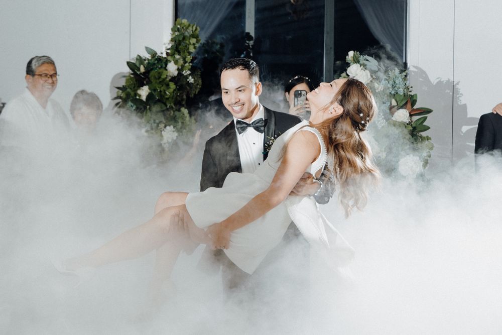 A bride and groom dancing together surrounded by fog effects captured by Apertured Media Auckland Wedding Photographer.