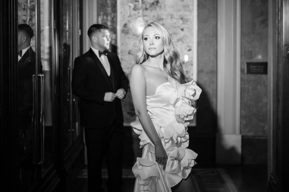 Black and white photo in vintage style showing formal attire against textured wall.