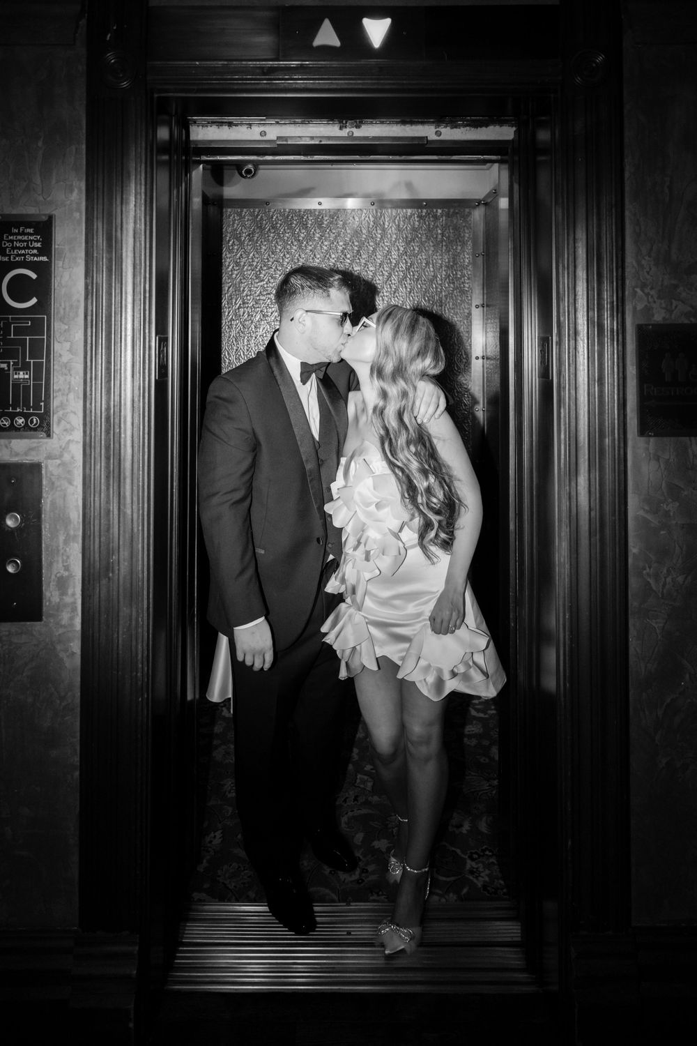 Black and white intimate portrait in classic elevator with art deco details.