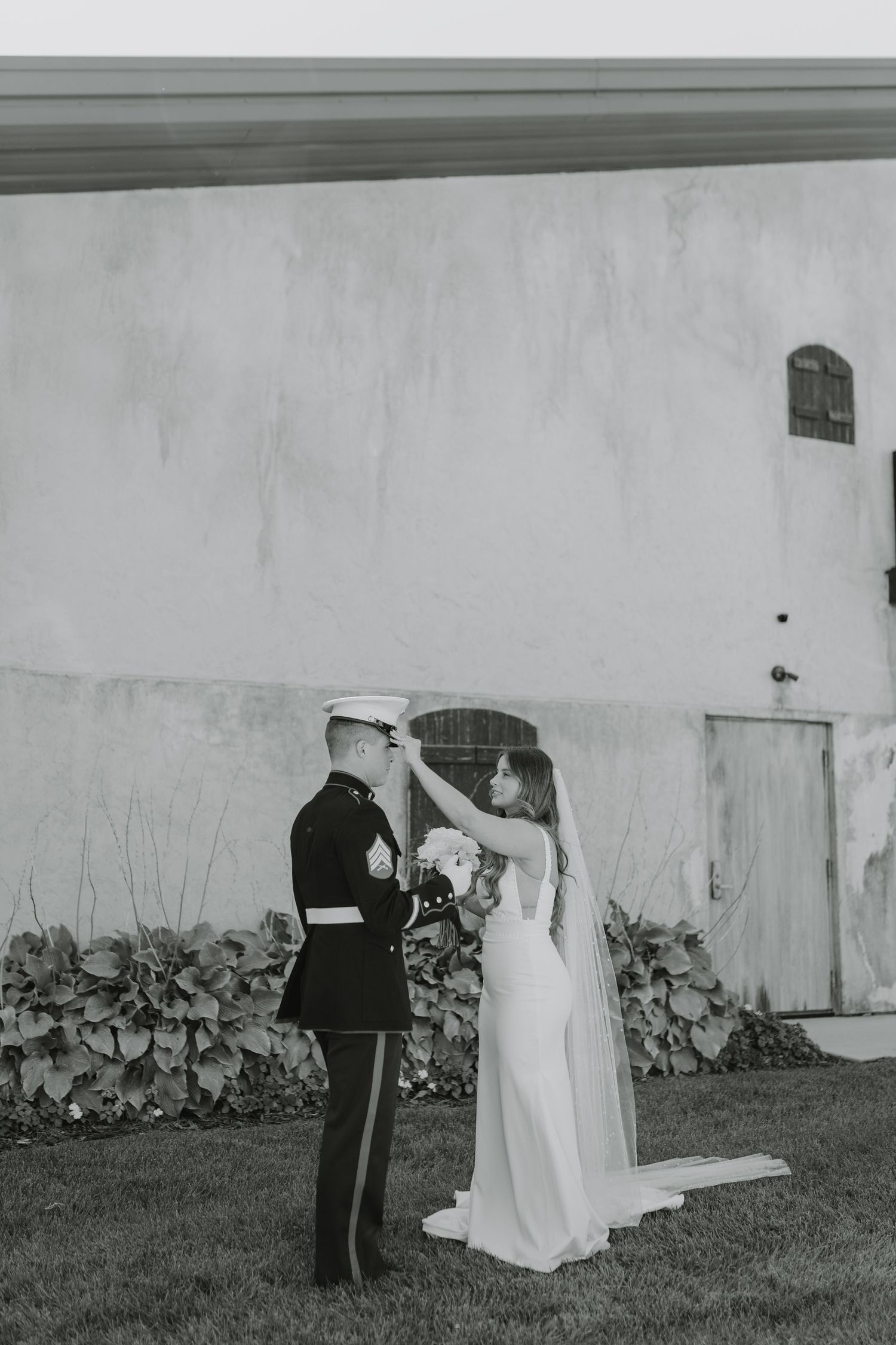 A bride fixes her groom's military uniform during their first look