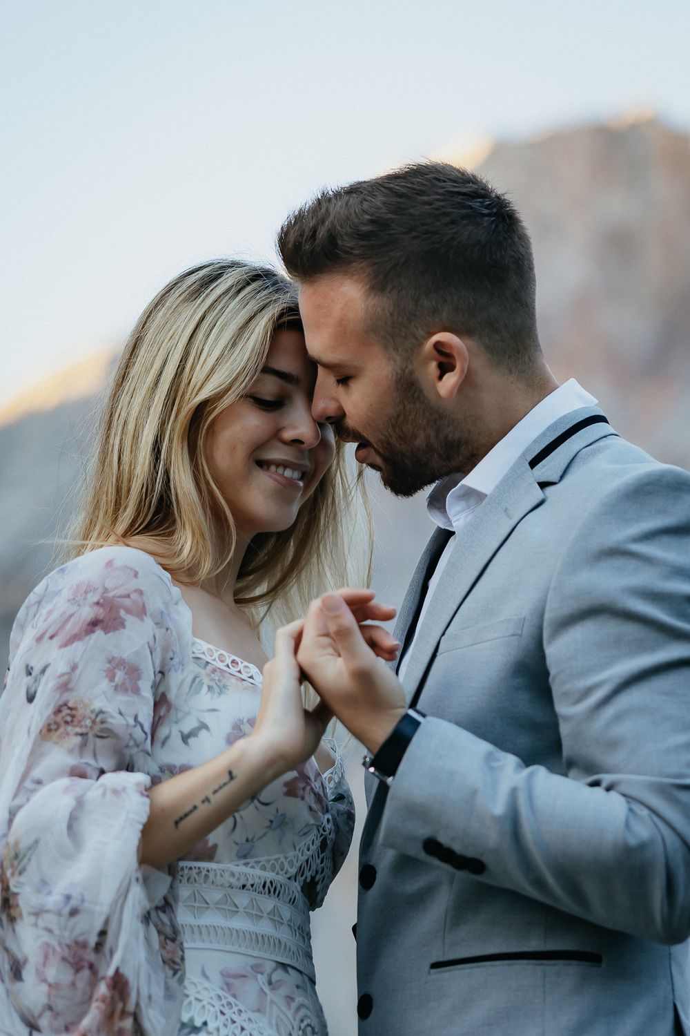 Intimate portrait of a couple sharing a tender moment with mountains in the background.