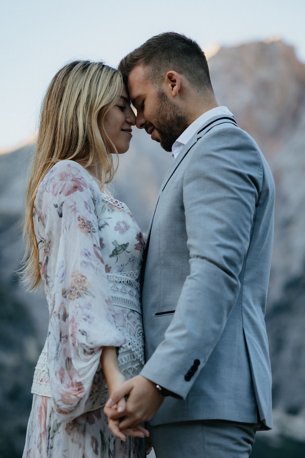 Close-up of an affectionate embrace set against dramatic mountain scenery.