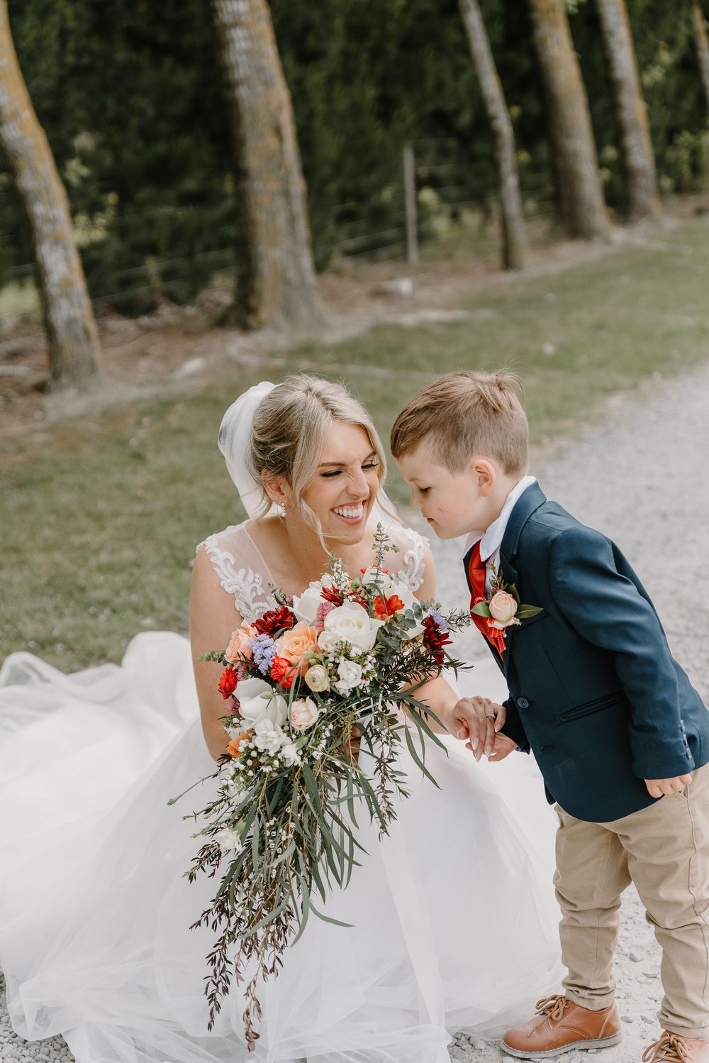 A sequence of candid wedding photos shows the bride with a young boy in a blue suit sharing playful moments on a path.
