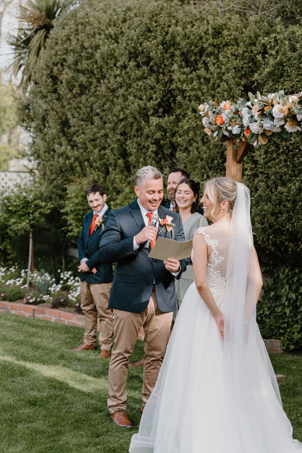 Emotional first look and candid reactions between newlyweds during outdoor garden wedding ceremony.