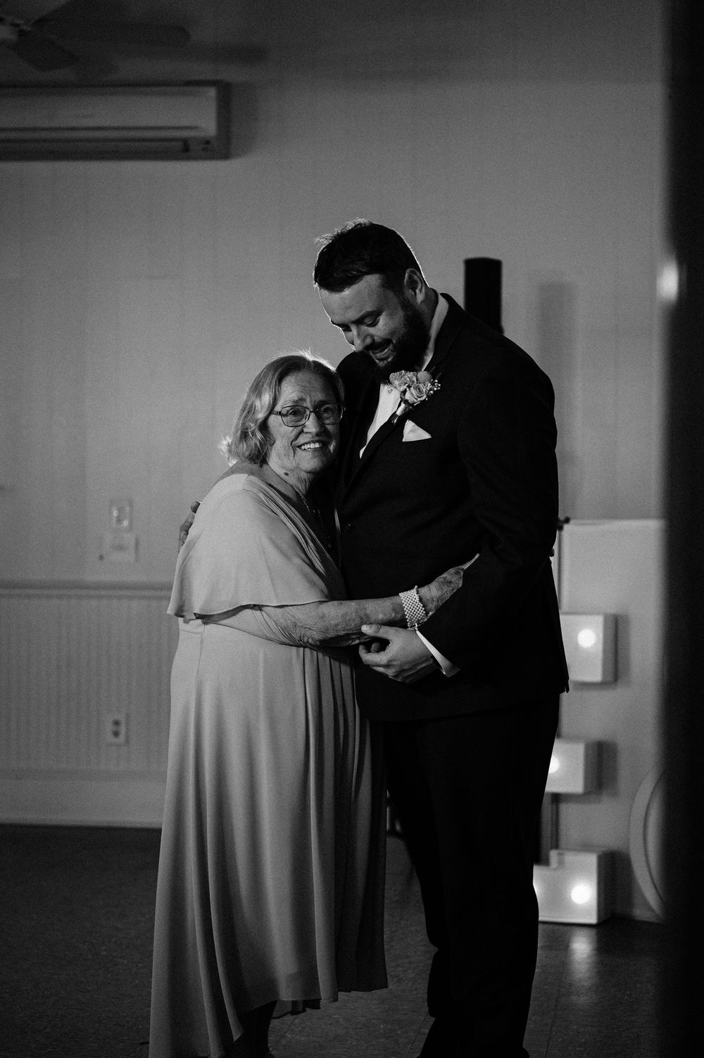 A tender black and white moment of a mother-son dance at a wedding reception.