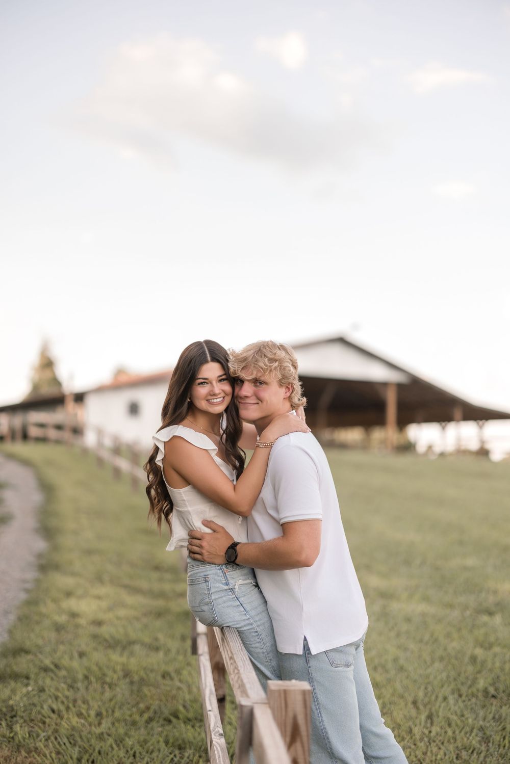 A couple embraces lovingly in a sun-drenched field during a romantic outdoor photo session.