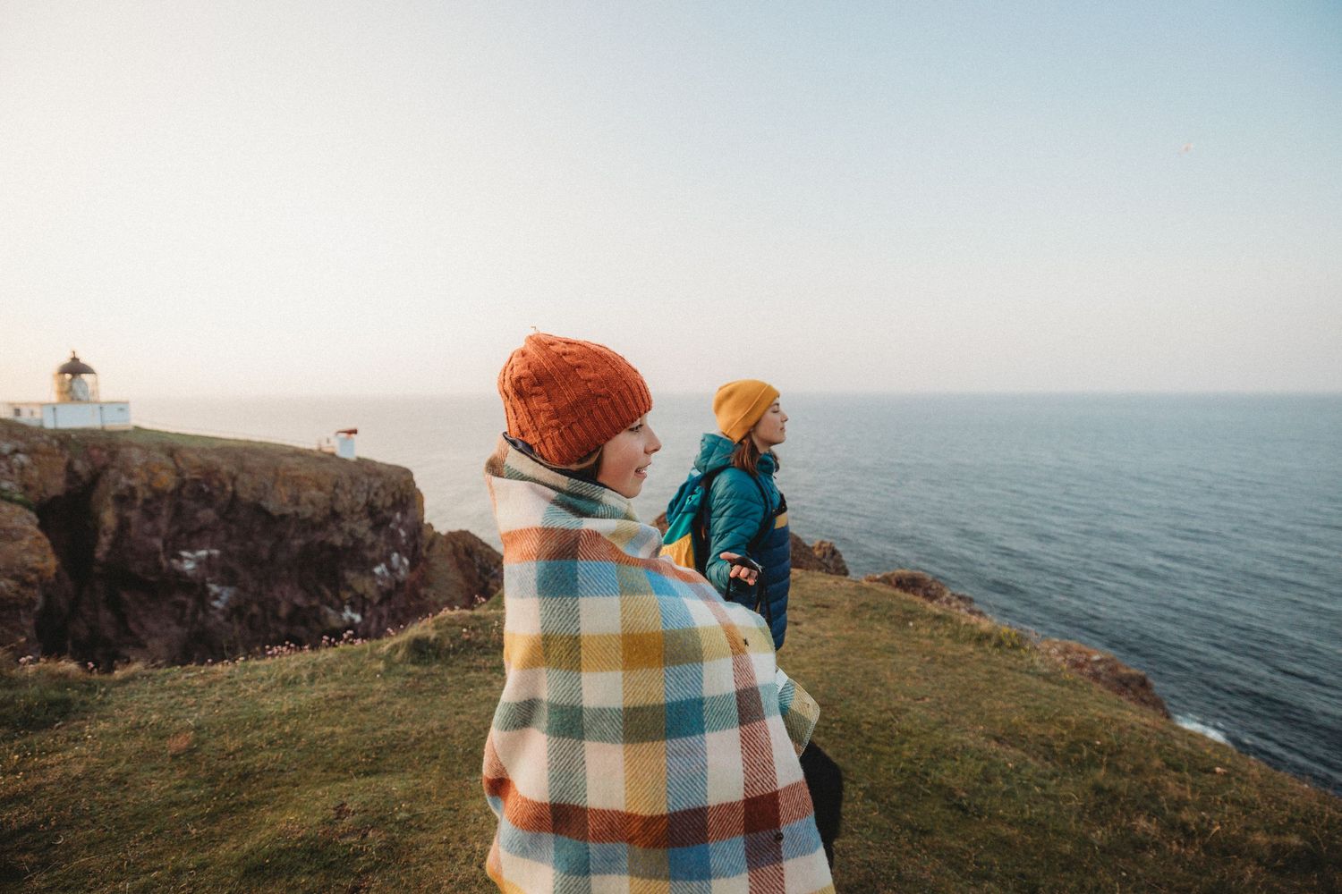 A series of scenic coastal images showing people enjoying views from cliffs overlooking the ocean at sunset.