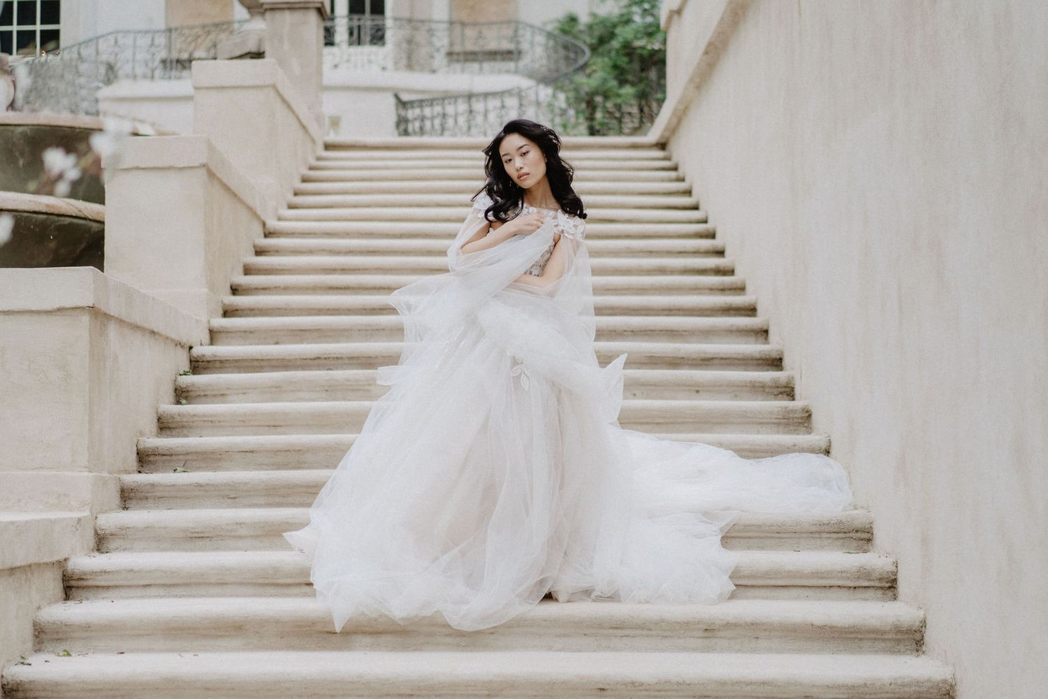 A romantic bridal portrait on grand stone steps of a historic building.