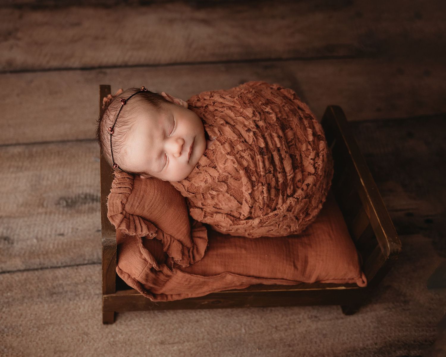Professional photo of a newborn baby on a tiny bed