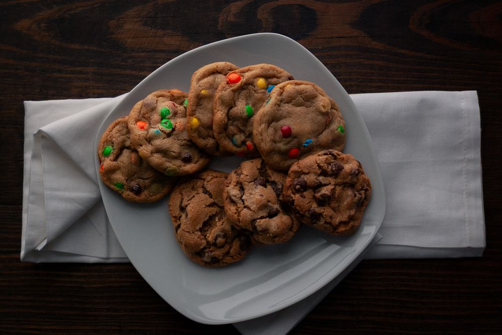 Plate of homemade chocolate chip cookies with M&Ms on white napkin. Product photography, San Diego, California