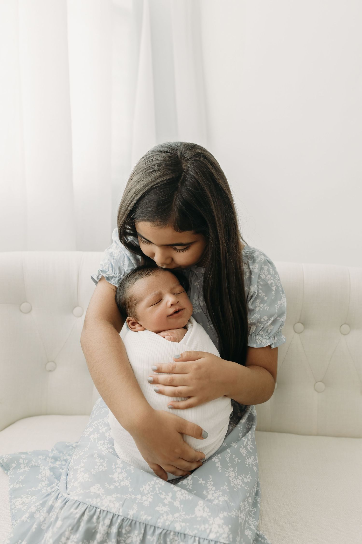 Newborn studio session with sibling holding baby, captured in Tampa photography studio
