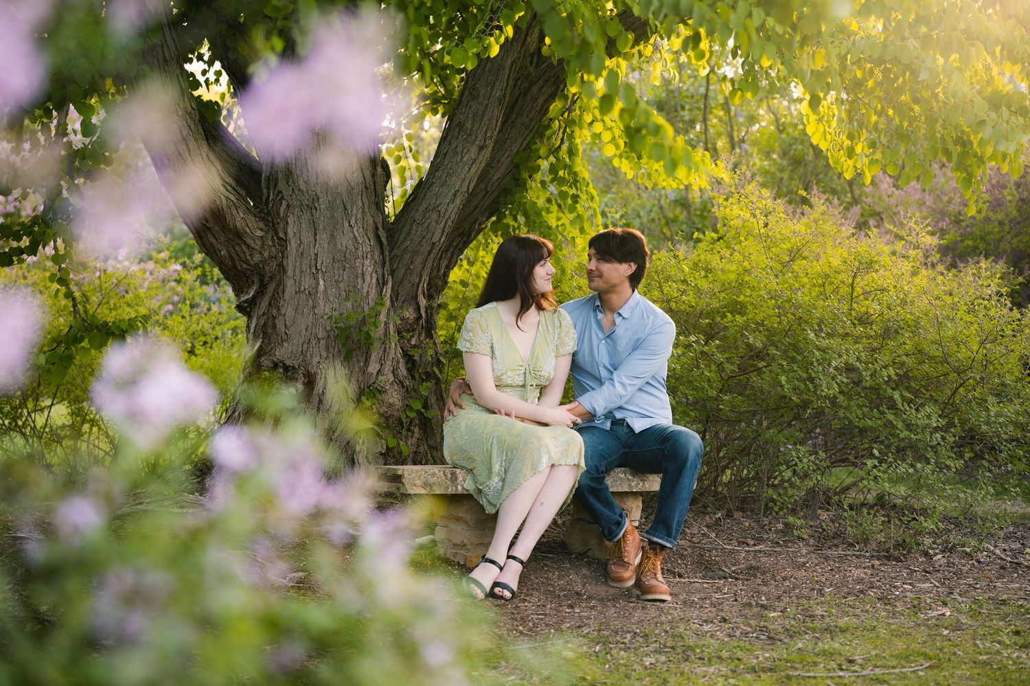 madison wi engagement couple photoshoot professional photographer spring uw arboretum blossoming cherry blossom trees lilacs sitting bench
