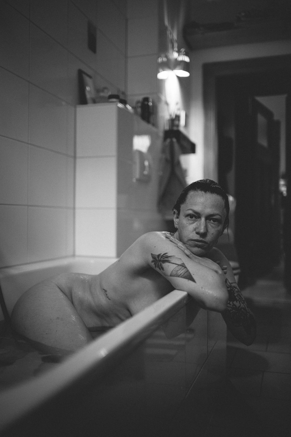 A black and white sequence of images showing someone in a moody bathtub scene with dramatic shadows and lighting.