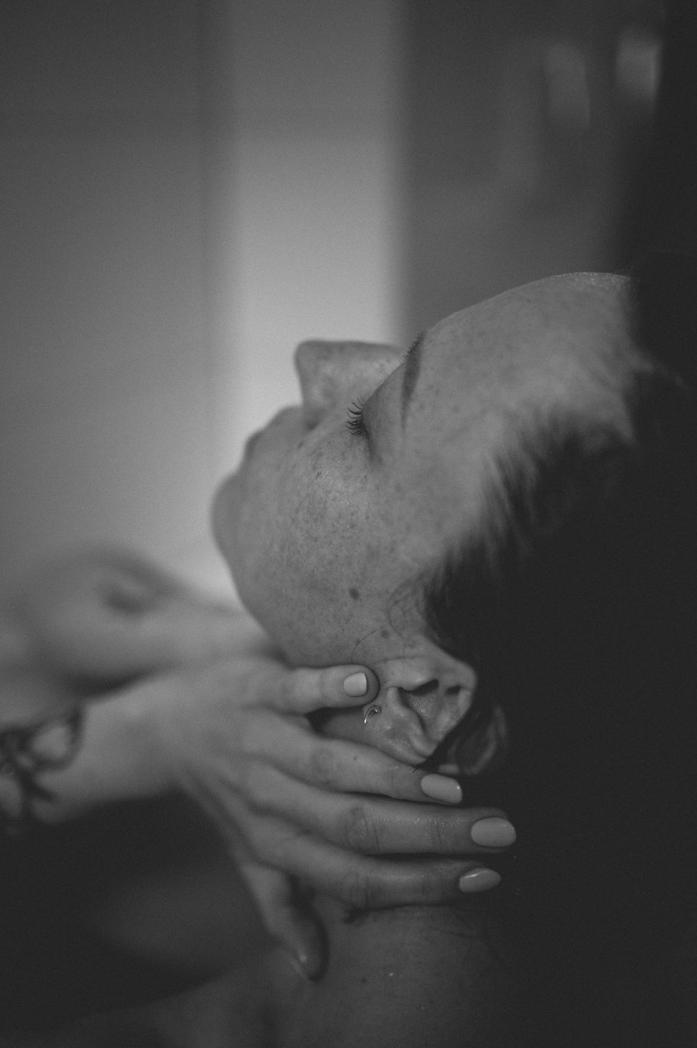 A black and white artistic photo series showing hands gently caressing and touching a bald head.