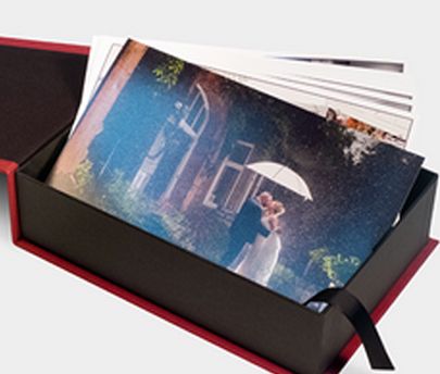 A red-trimmed black box displays colorful artwork prints being revealed in a sequential unboxing presentation.