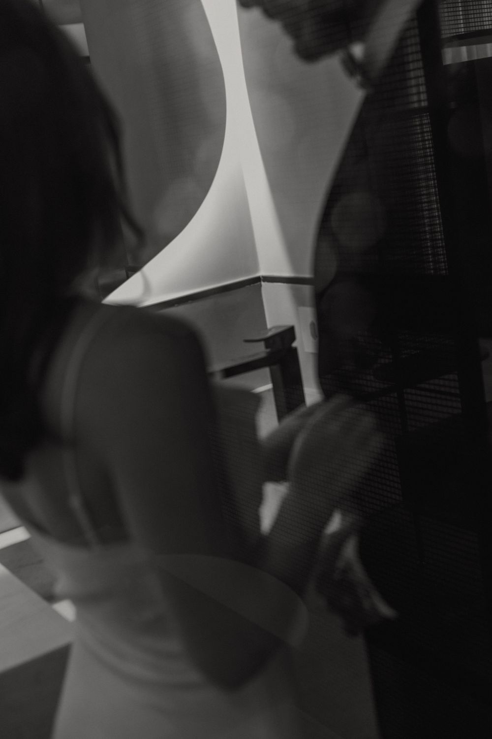 Blurred black and white artistic photograph showing movement and shadows in an interior setting.