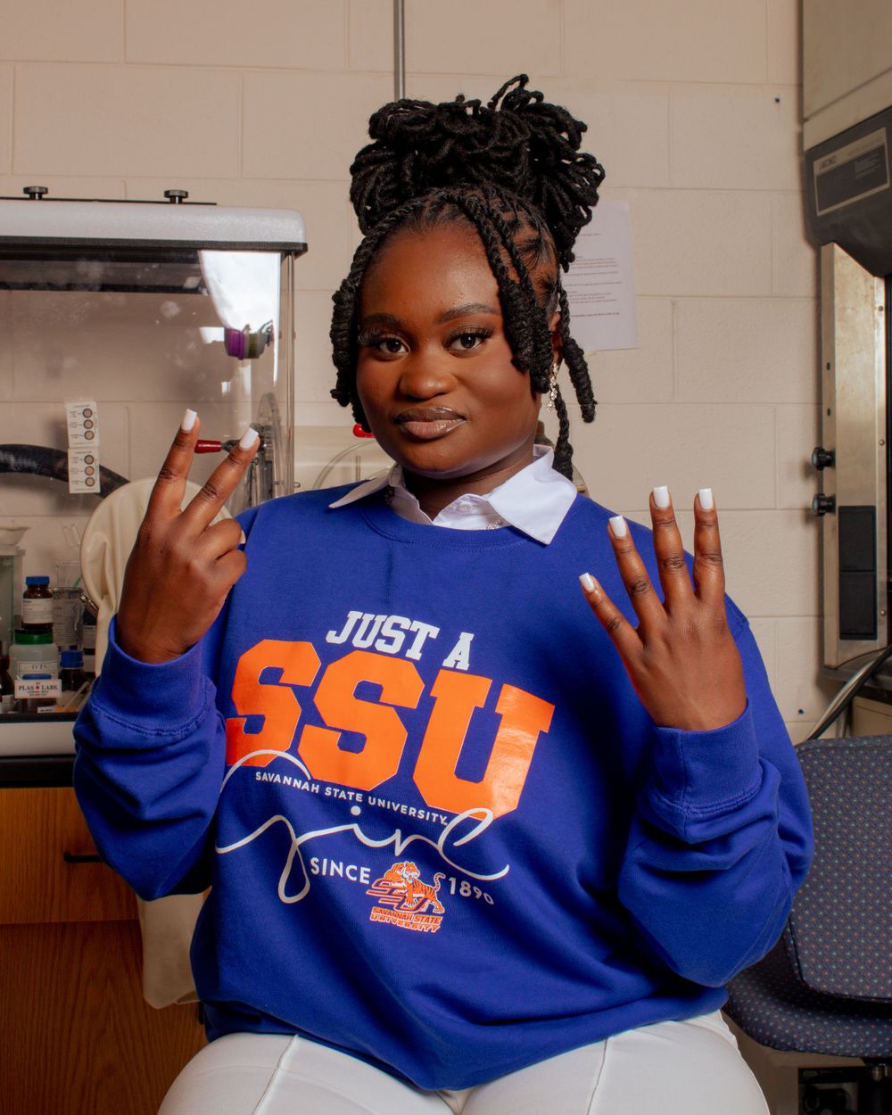 Student in bright blue SSU sweatshirt posing in campus setting.