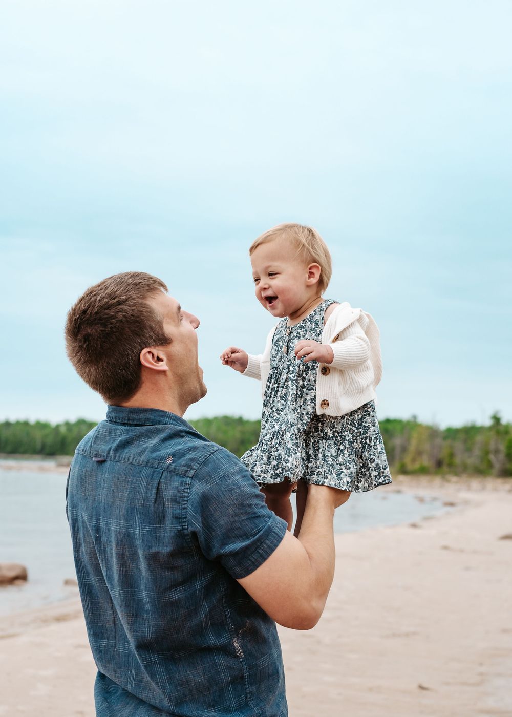 A sweet candid moment captured in a series showing playtime and laughter at the beach on a sunny day.