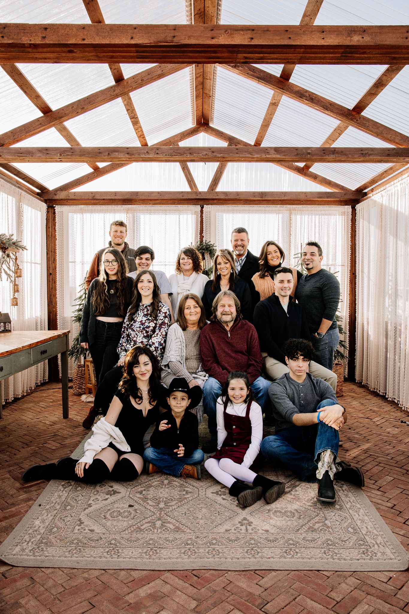 Extended family of 20 portraits. posing for family pictures in a greenhouse in windsor colorado. liz rivas colorado photographer
