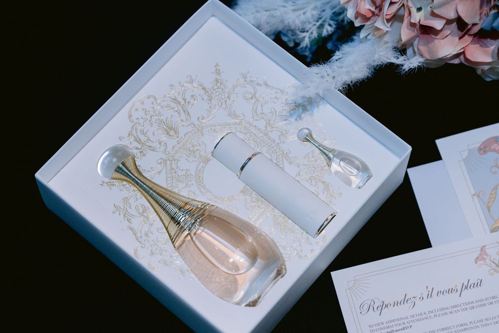 Elegant white gift box containing perfume bottle and wedding accessories with delicate lace details.