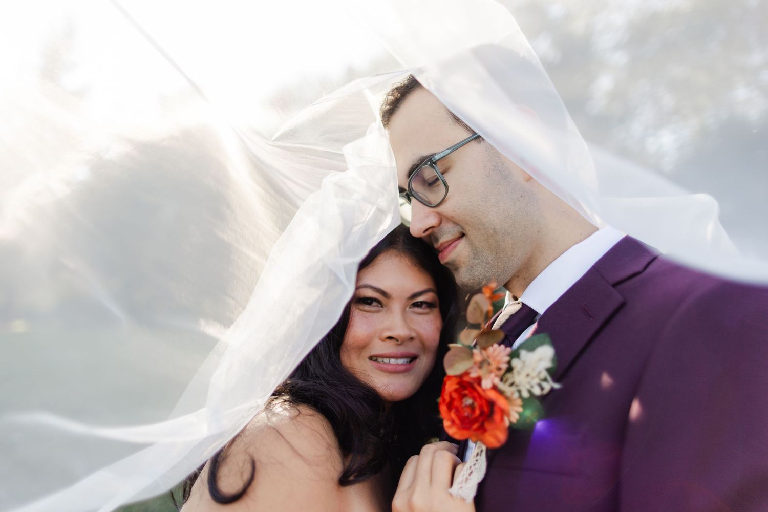 Romantic nighttime portrait of couple kissing under clear umbrella in the rain.