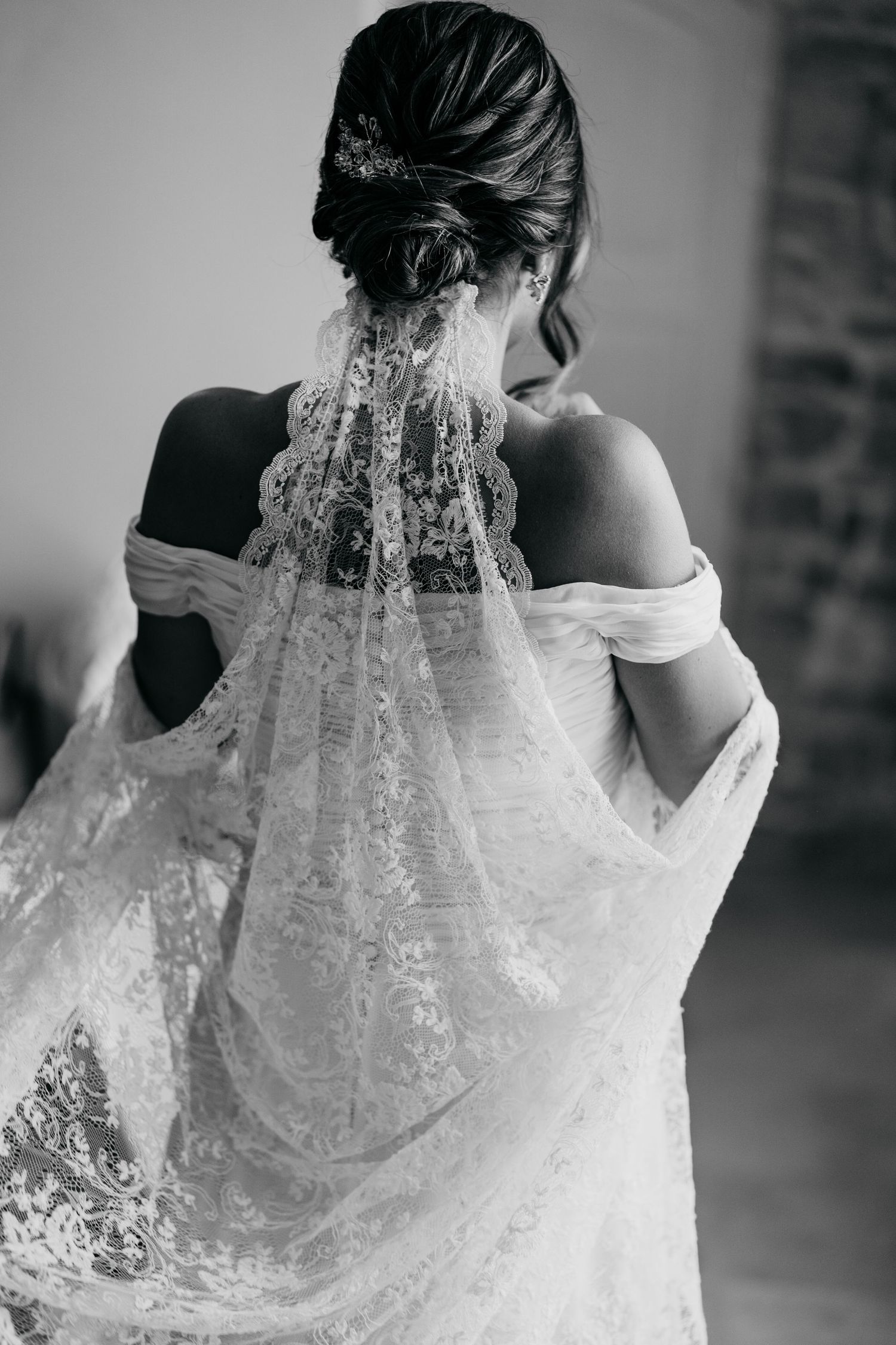 Back view of an elegant bridal hairstyle with delicate lace veil in black and white.
