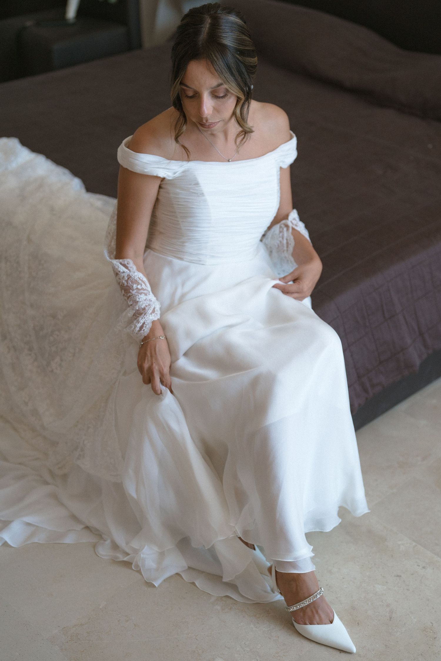 Wedding dress details with focus on hemline and white bridal shoes.