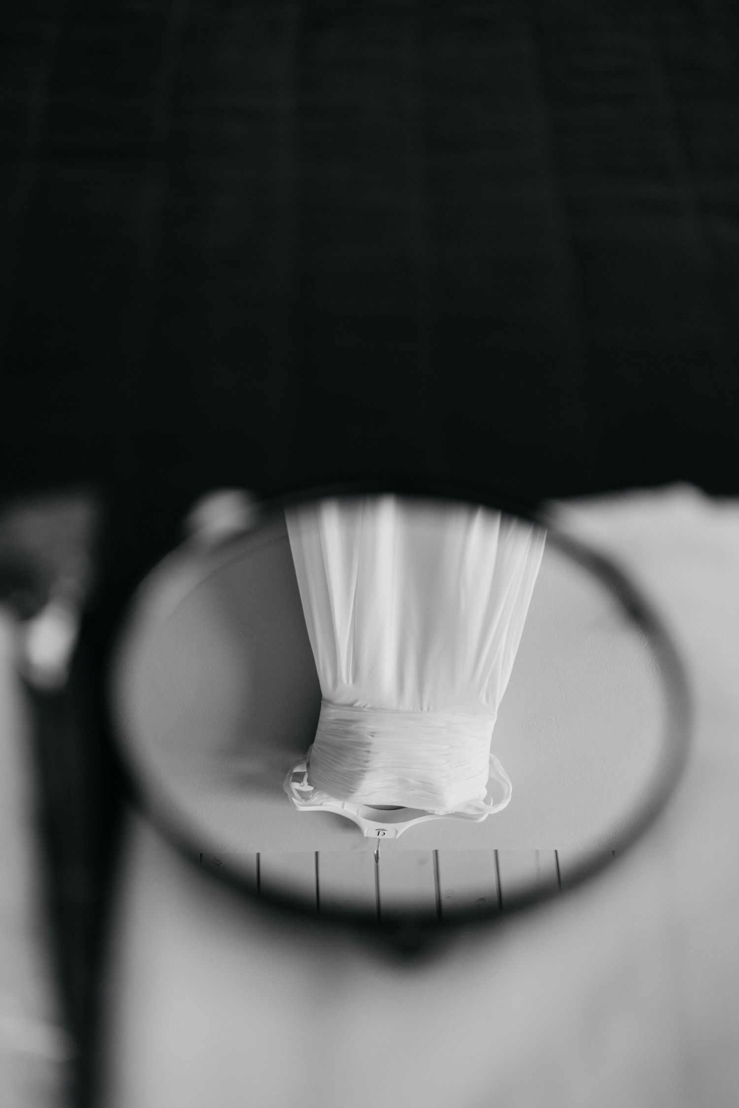 Close-up abstract black and white details of a wedding dress fabric with delicate pleating.