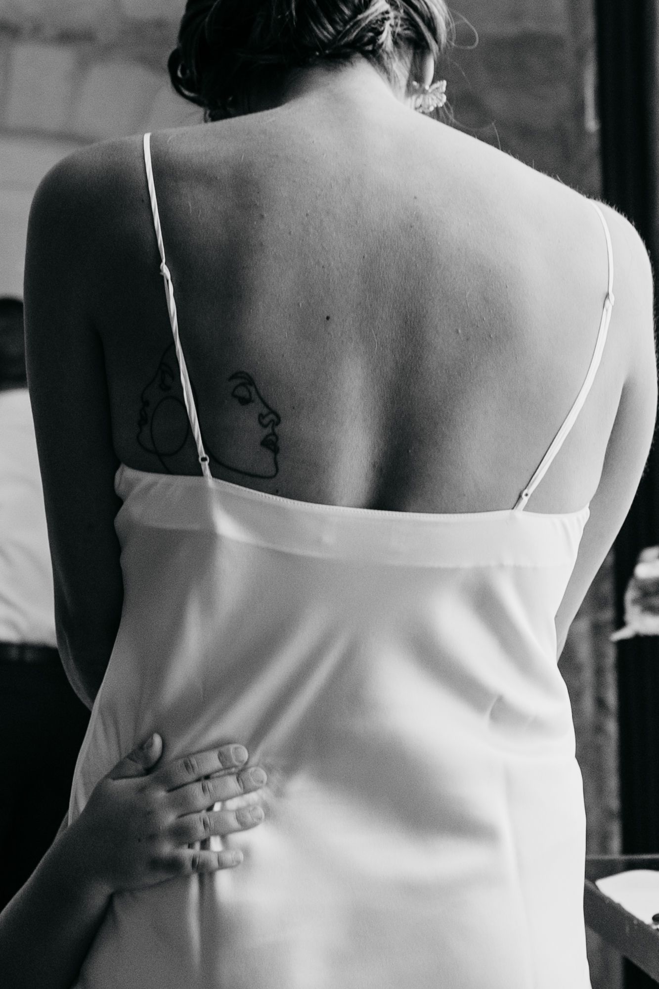 Black and white close-up shots of bridesmaid dresses showing delicate white straps and fabric details.