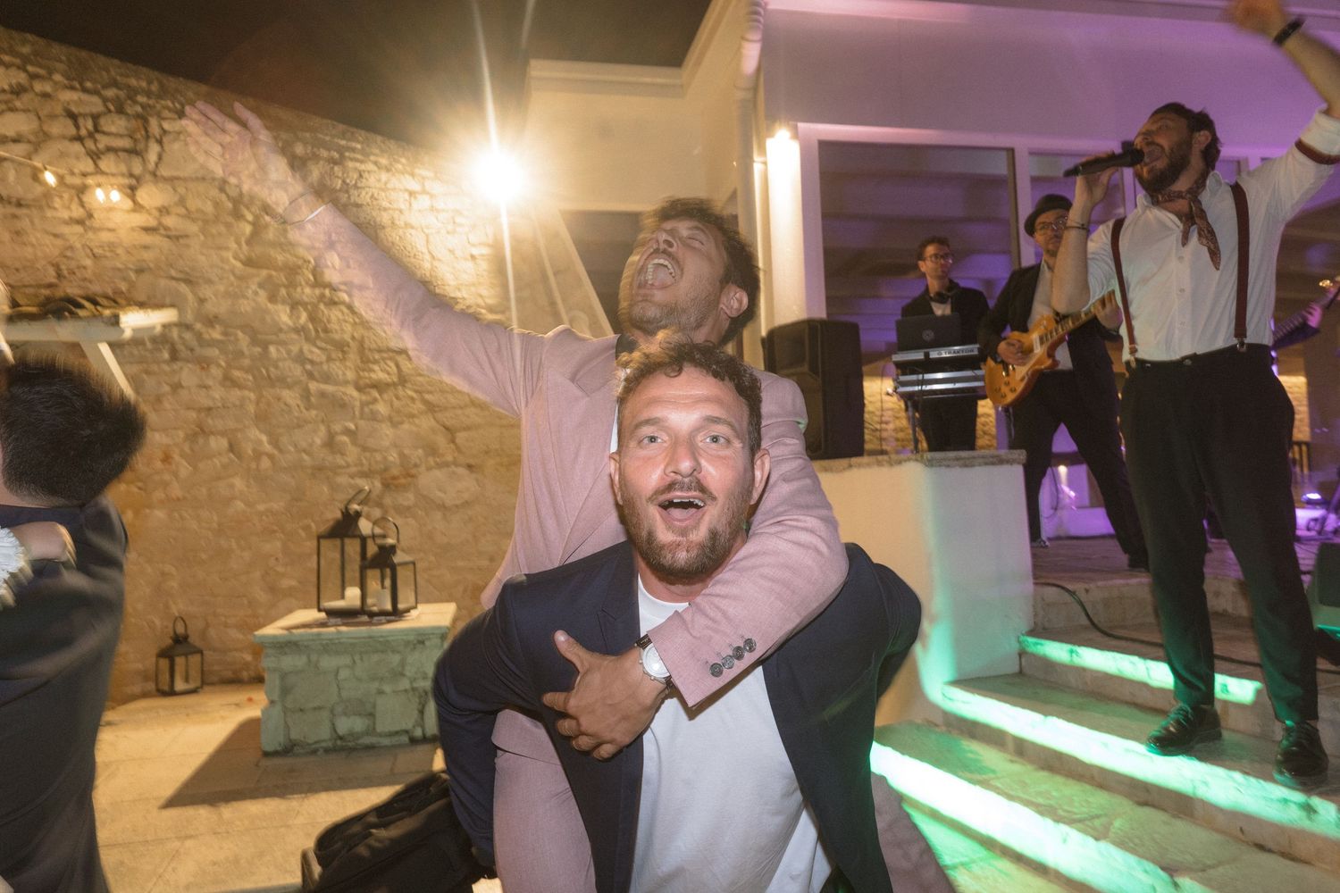 Joyful celebration with guests and performers at an illuminated indoor venue.