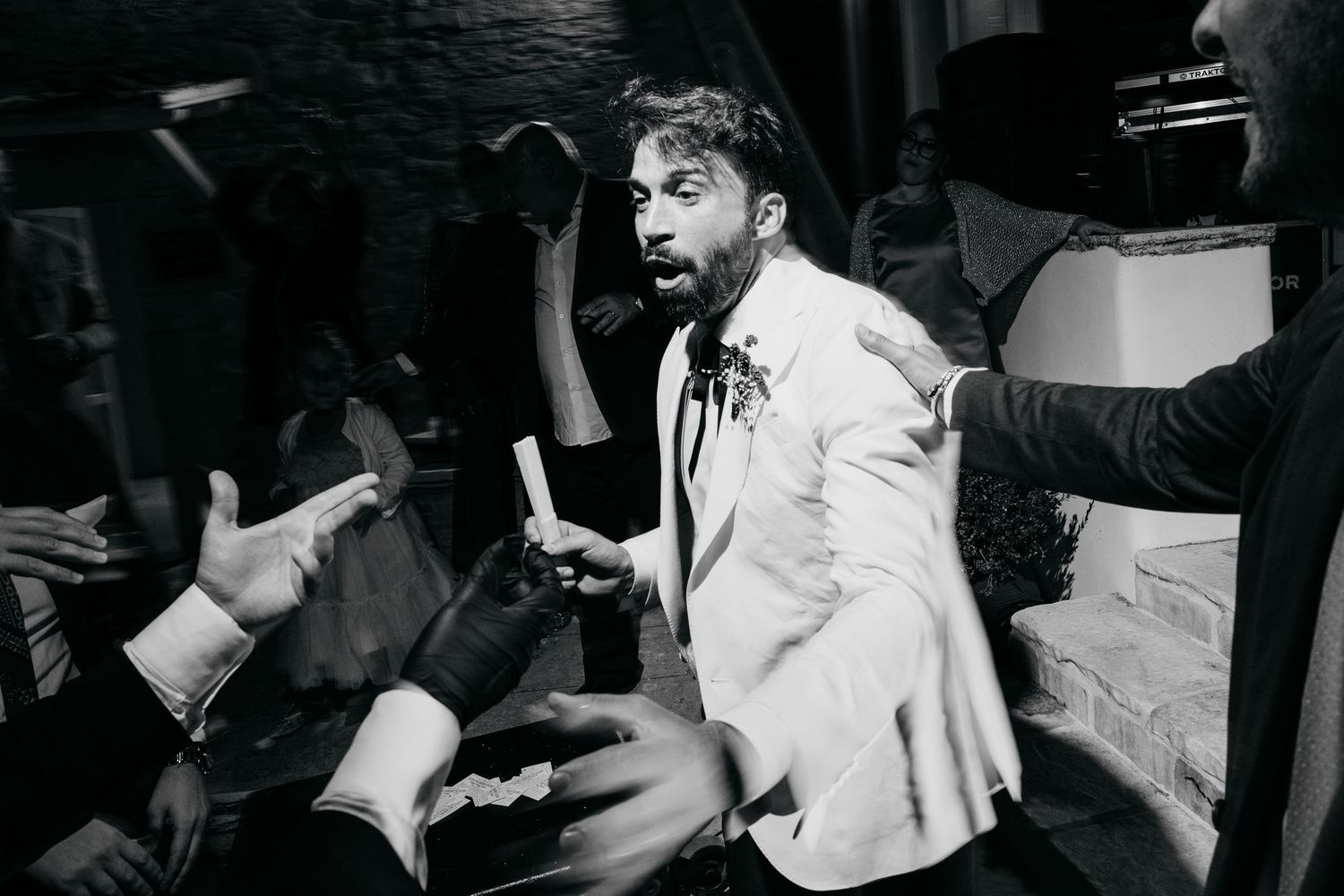 Energetic dancing and celebration during a wedding reception in black and white.
