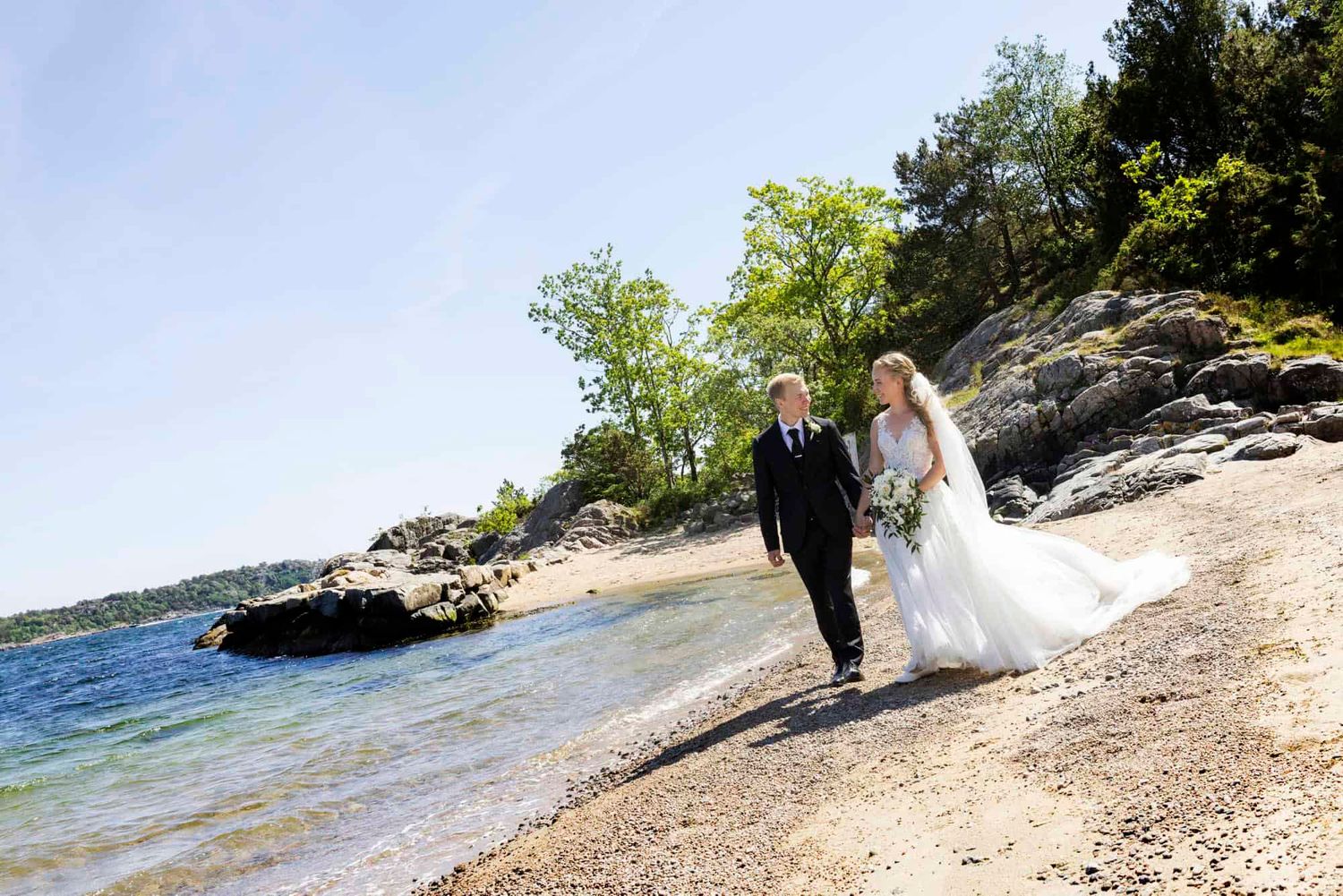 Brudepar går mes de ser på vheradnre lang stranden på Njervesanden i Spangereid Lindesnes