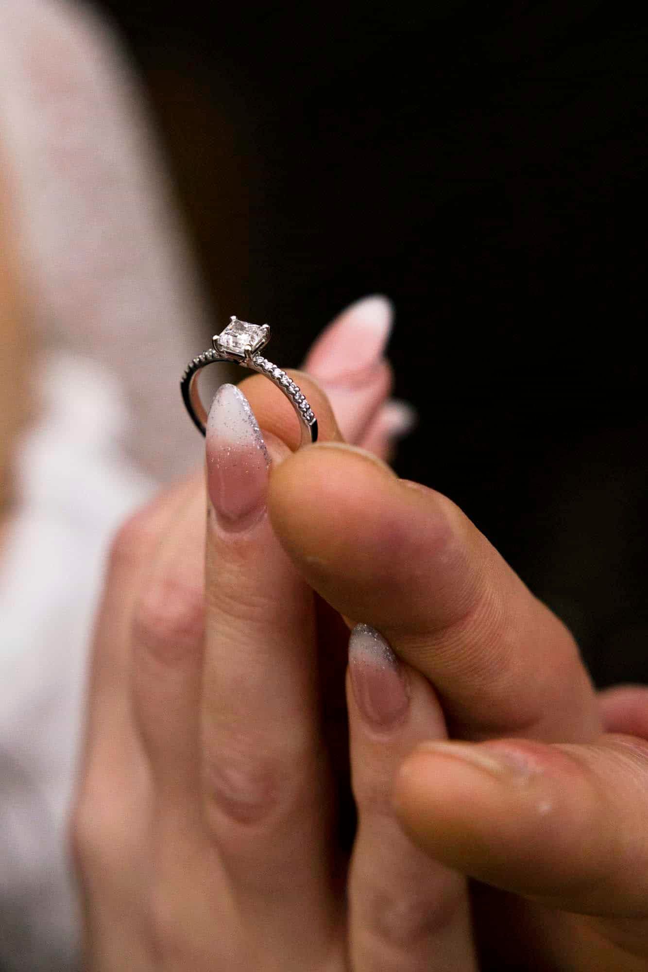 Brud som holder gifteringen sin mellom fingrene