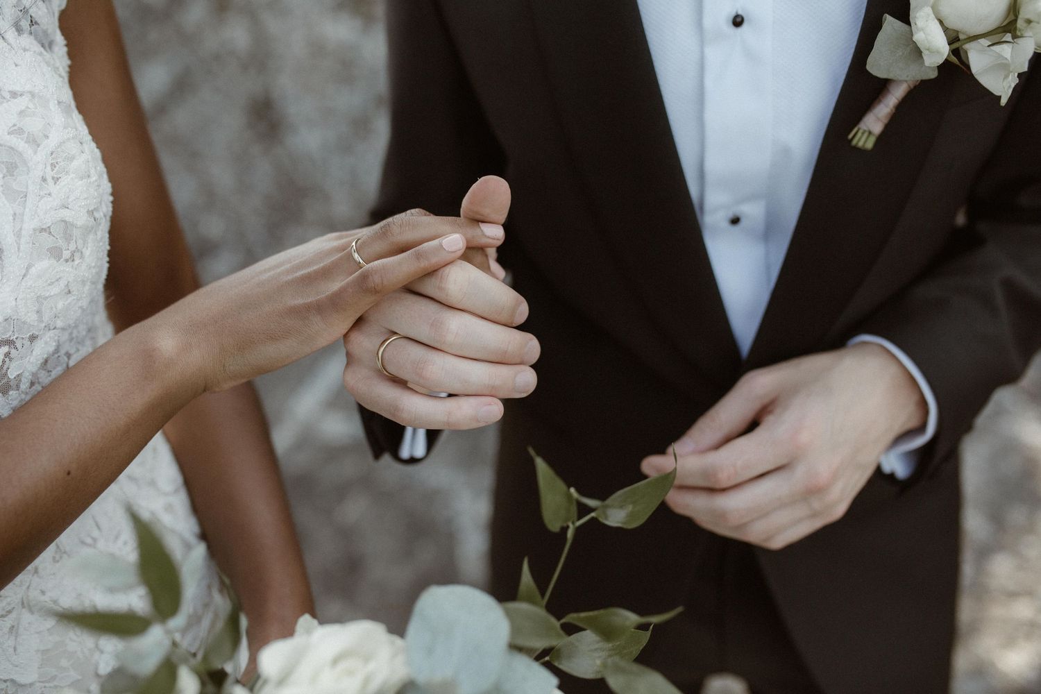 Close up shot of hands exchanging wedding rings during a ceremony.