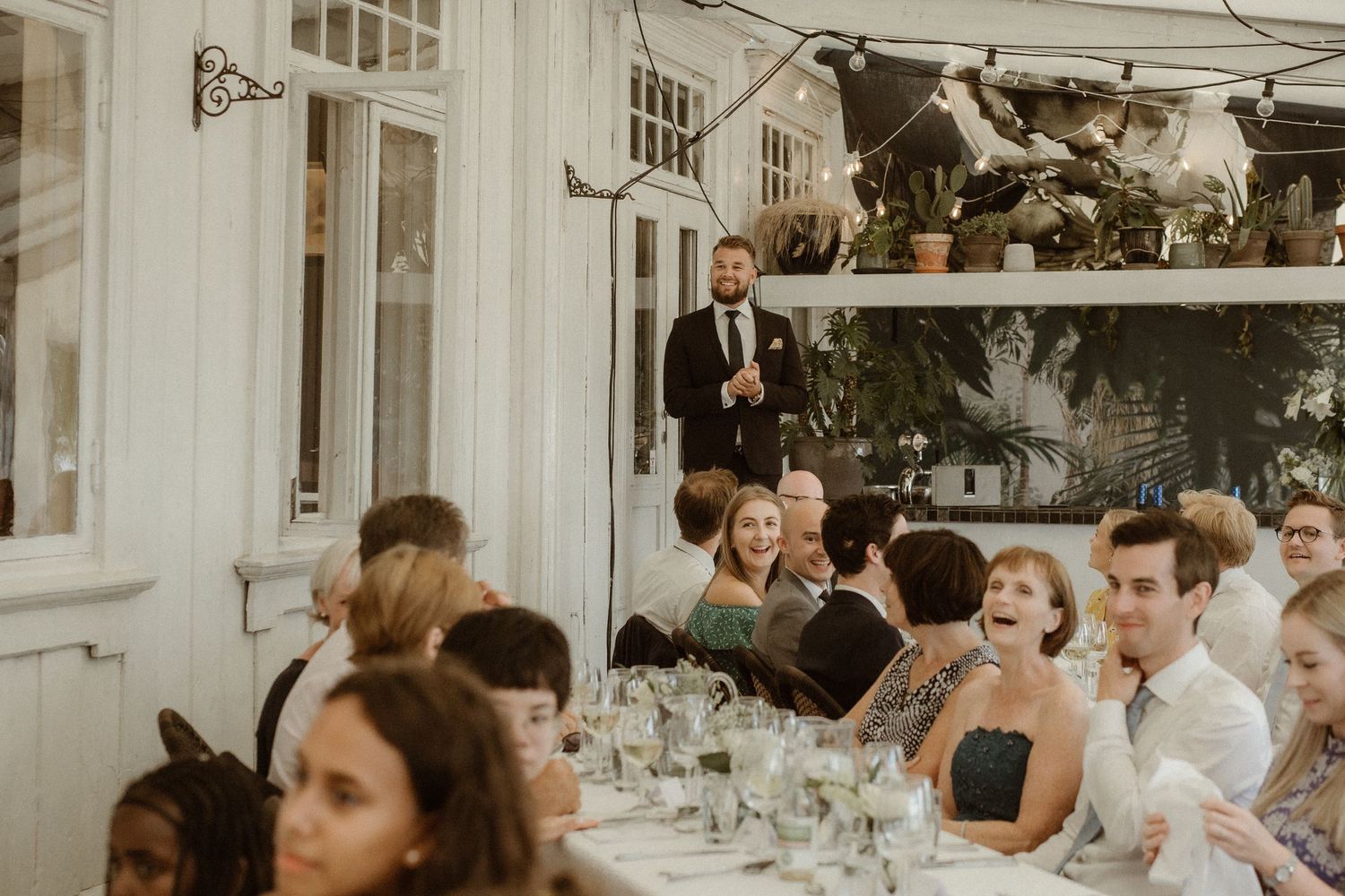 Guests enjoying an elegant outdoor wedding reception with white tablecloths and table settings.