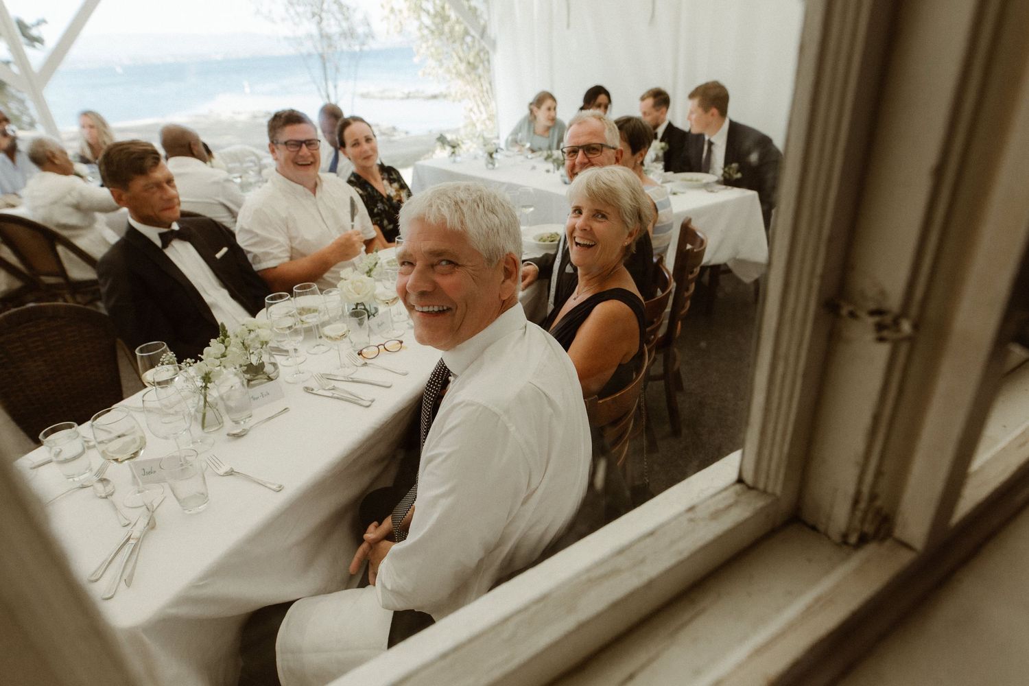 Wedding guests seated at long tables during an intimate reception gathering.