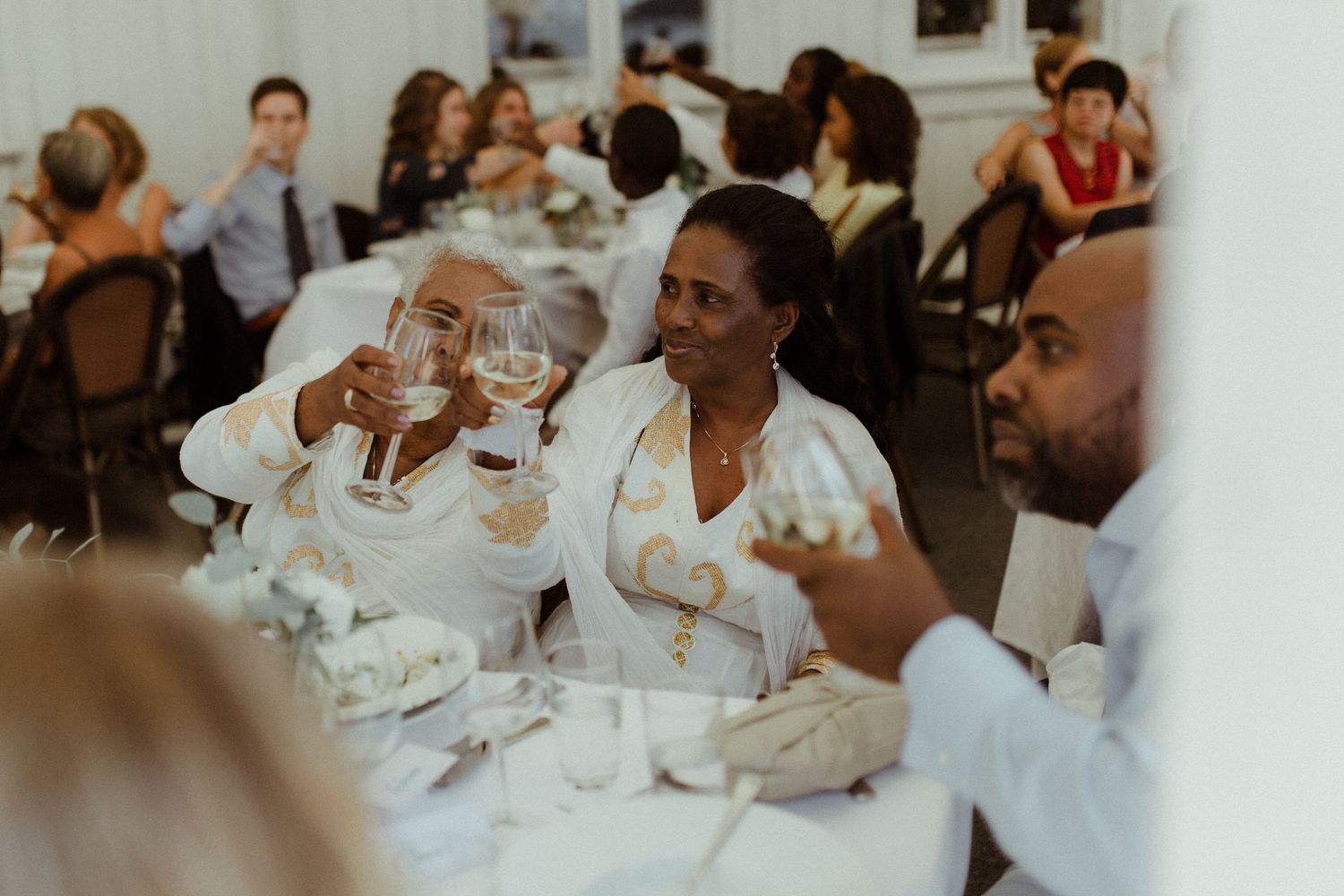 Wedding guests enjoy drinks and conversation at a reception table.