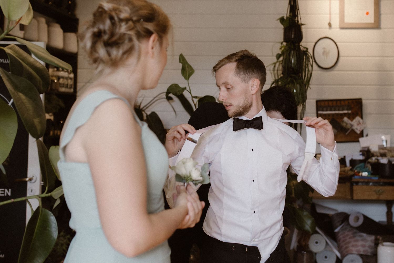 A couple shares an intimate moment during a wedding ceremony in a rustic indoor setting.