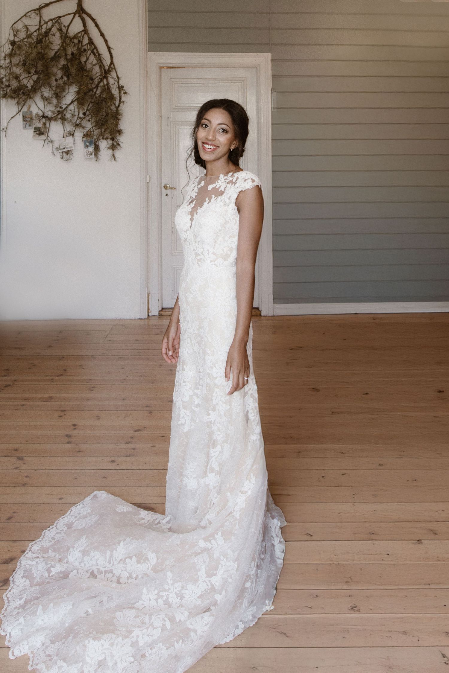 Full-length shot of a bride in a fitted lace wedding gown with cathedral train.