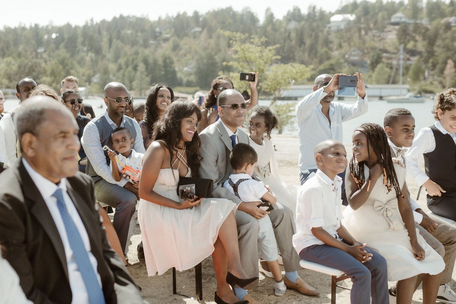 Wedding guests seated outdoors with mountain scenery in the background.