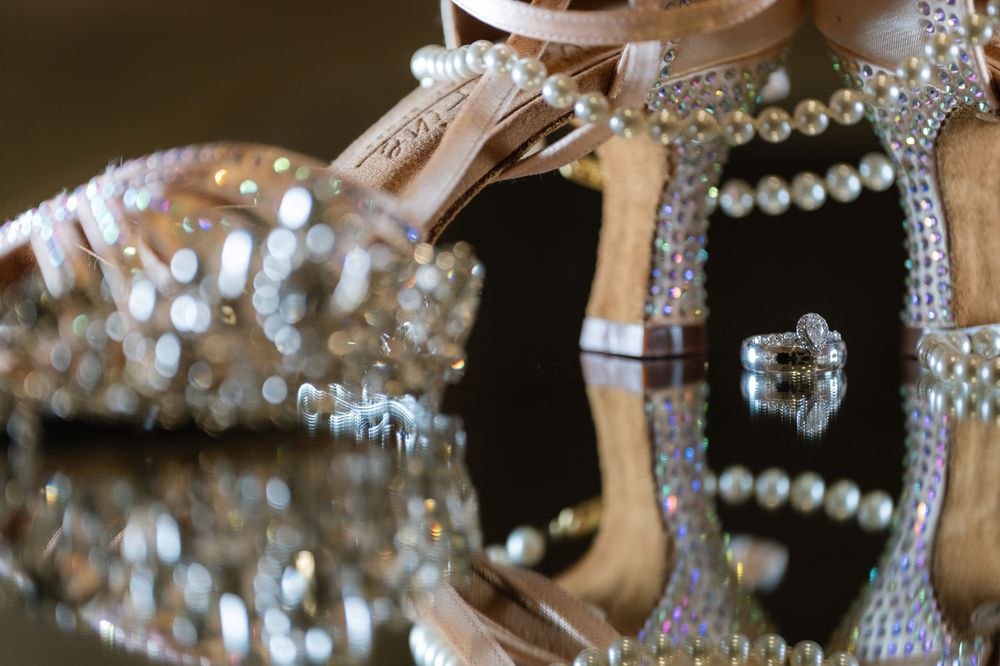 Elegant pearl and crystal jewelry pieces sparkle in a reflective display with glittering embellishments.