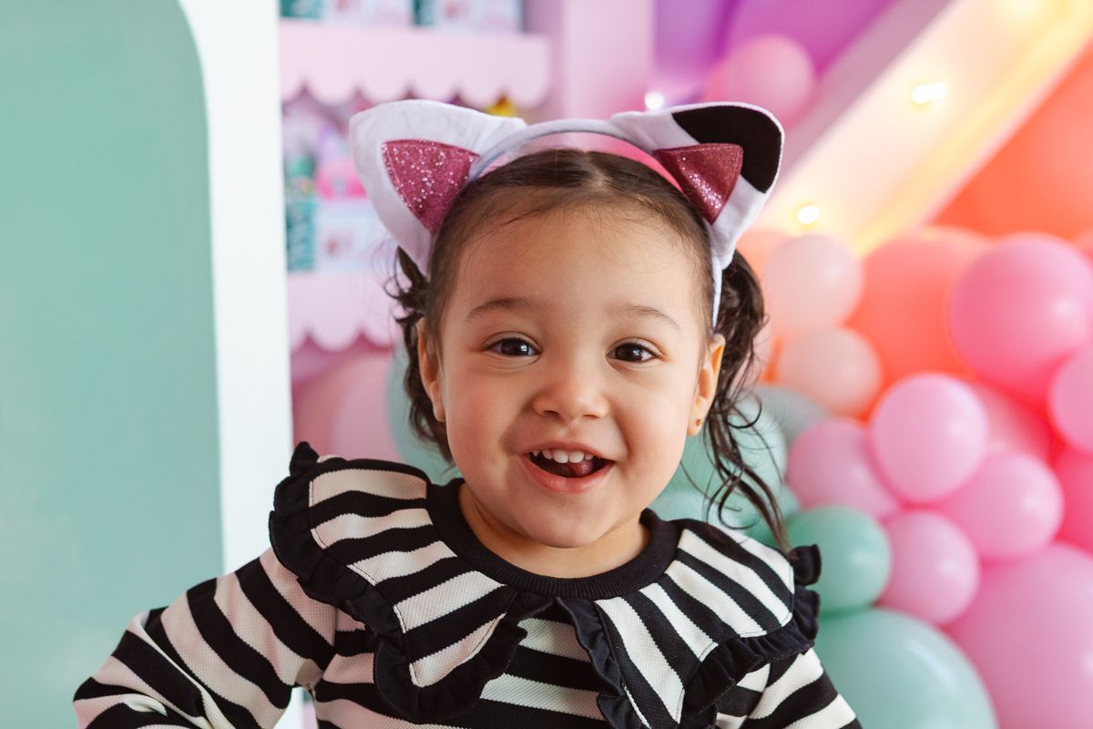 Gaby’s Dollhouse birthday celebration in NYC—birthday girl beams with happiness in front of her festive party decor