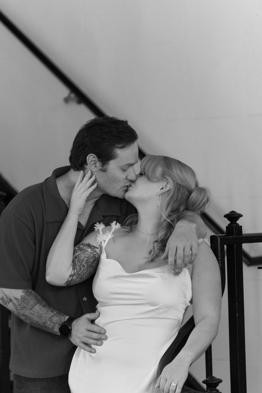 A romantic black and white photograph captured on a staircase.